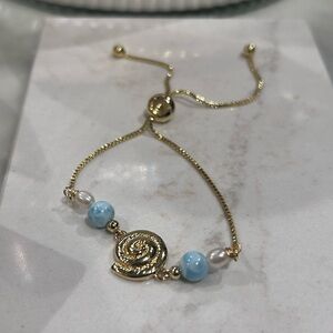 Gold stainless steel bracelet with larimar, and freshwater pear and Spiral Charm